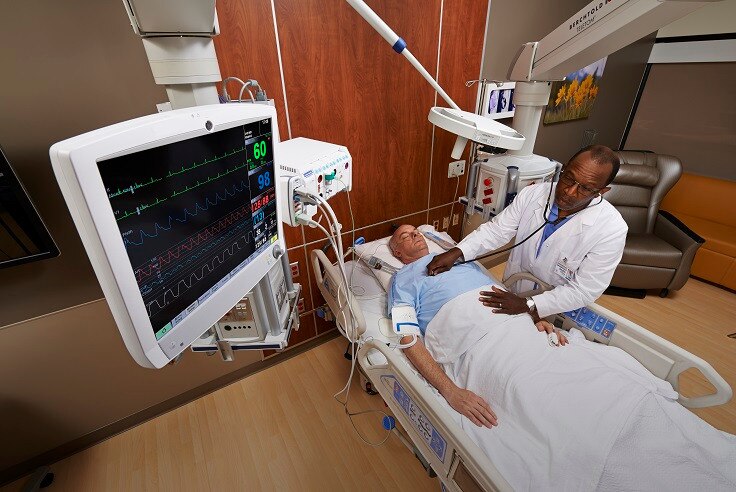 A caregivers is touching at the display screen of GE Healthcare CARESCAPE B850 patient monitor.